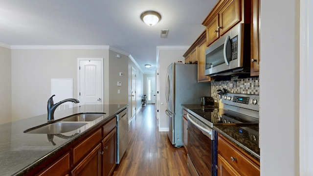 kitchen featuring ornamental molding, appliances with stainless steel finishes, dark wood-type flooring, and sink