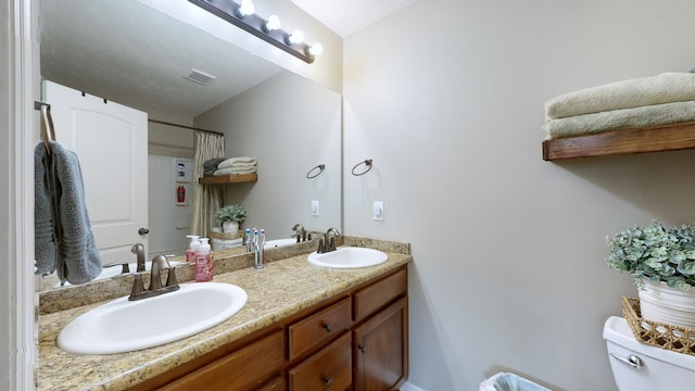 bathroom featuring curtained shower, vanity, and toilet