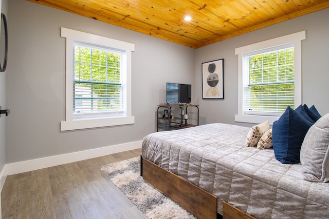 bedroom featuring wood ceiling, multiple windows, and hardwood / wood-style floors