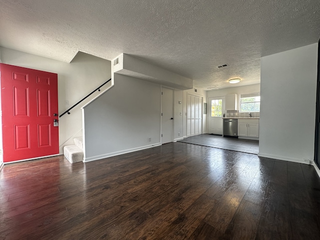 unfurnished living room featuring a textured ceiling, sink, and dark hardwood / wood-style flooring