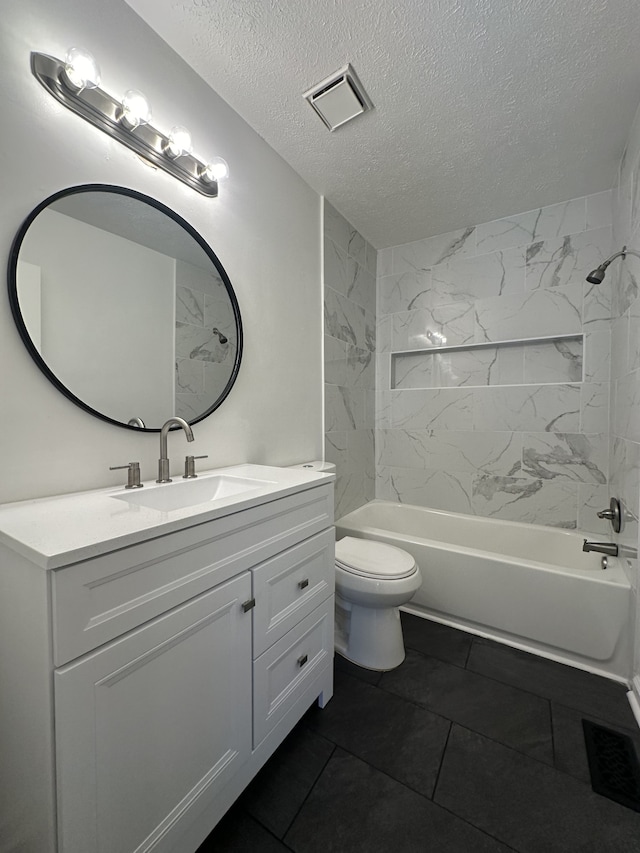 full bathroom featuring vanity, tiled shower / bath combo, toilet, and a textured ceiling