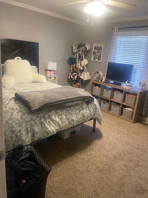 carpeted bedroom featuring ornamental molding and ceiling fan