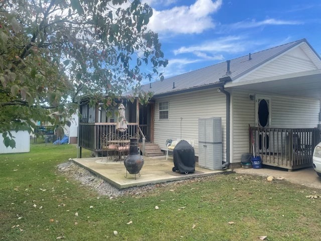 back of property with a patio area and a lawn