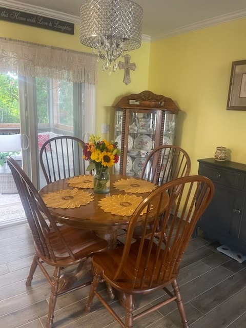 dining area with crown molding, a chandelier, and dark hardwood / wood-style flooring