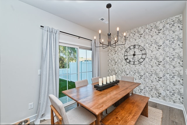 dining space featuring an inviting chandelier and hardwood / wood-style flooring