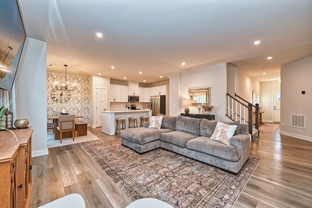 living room featuring a notable chandelier and light hardwood / wood-style floors