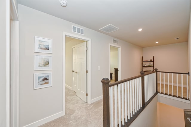 hall featuring light carpet