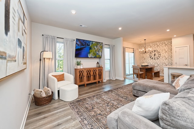 living room featuring light wood-type flooring and a notable chandelier