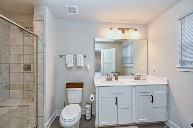 bathroom with walk in shower, hardwood / wood-style floors, vanity, and toilet