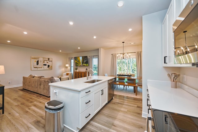 kitchen featuring light hardwood / wood-style floors, a kitchen island with sink, white cabinetry, stainless steel appliances, and decorative light fixtures