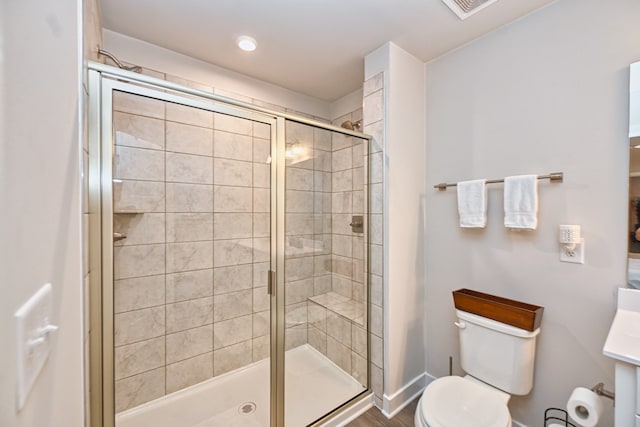 bathroom featuring an enclosed shower and toilet