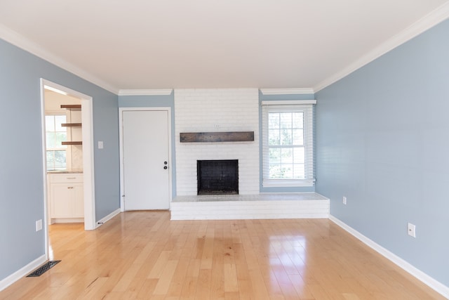 unfurnished living room featuring light wood-type flooring, a fireplace, and crown molding