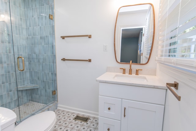 bathroom with vanity, a shower with shower door, and toilet