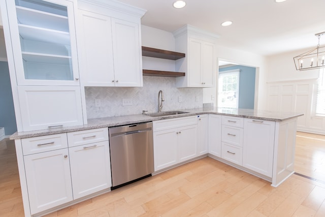 kitchen with white cabinets, hanging light fixtures, sink, stainless steel dishwasher, and light hardwood / wood-style floors