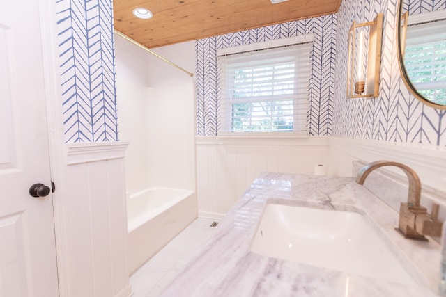 bathroom with a wealth of natural light, shower / bathtub combination, and vanity