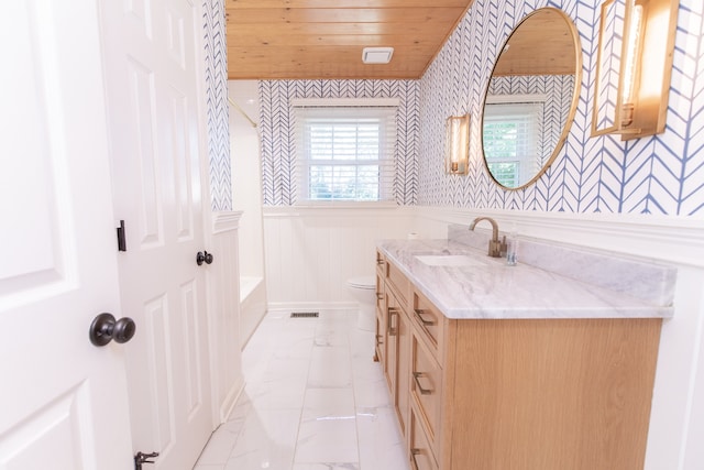 bathroom featuring vanity, a bathing tub, toilet, and wooden ceiling