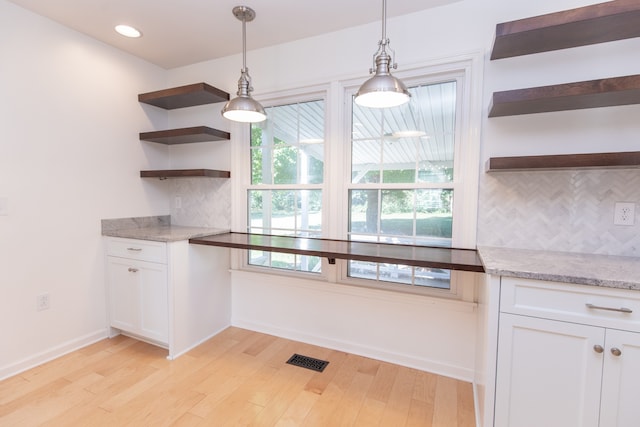 kitchen featuring decorative backsplash, white cabinets, and light wood-type flooring