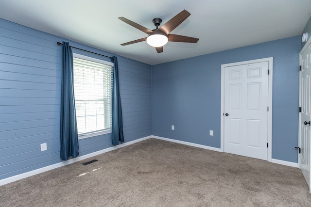 carpeted spare room with ceiling fan