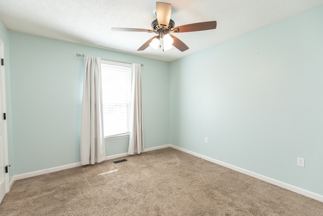 empty room with carpet, ceiling fan, and a textured ceiling