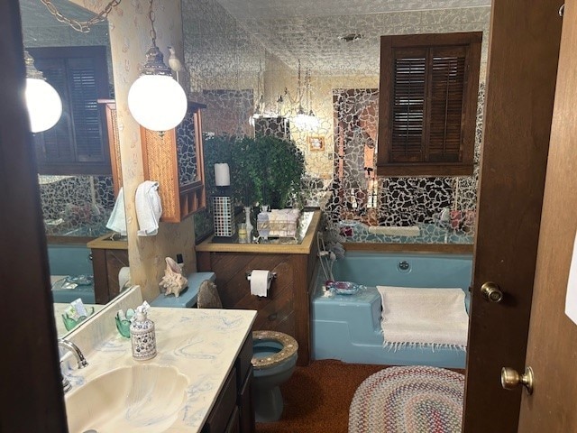 bathroom featuring a bath, vanity, and toilet