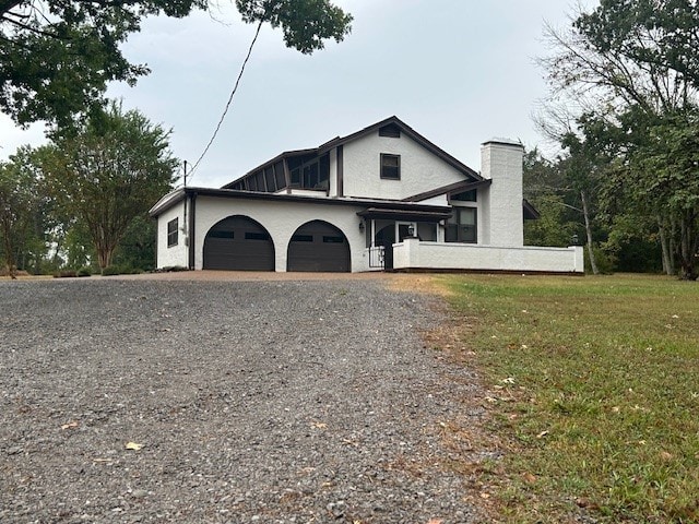 view of front of home with a garage and a front lawn