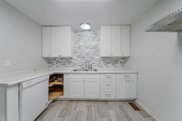 kitchen with white cabinets, dishwasher, sink, and exhaust hood