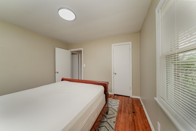 bedroom with dark hardwood / wood-style flooring