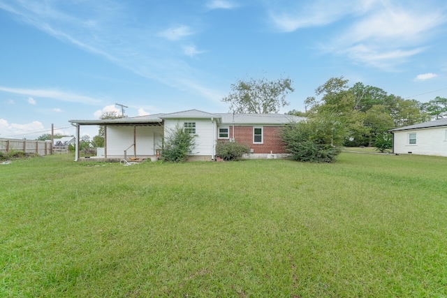 rear view of house featuring a yard