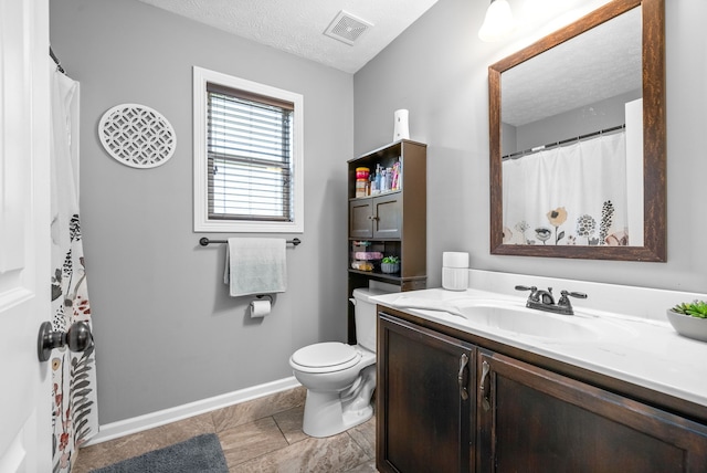 bathroom featuring tile patterned flooring, a textured ceiling, vanity, and toilet