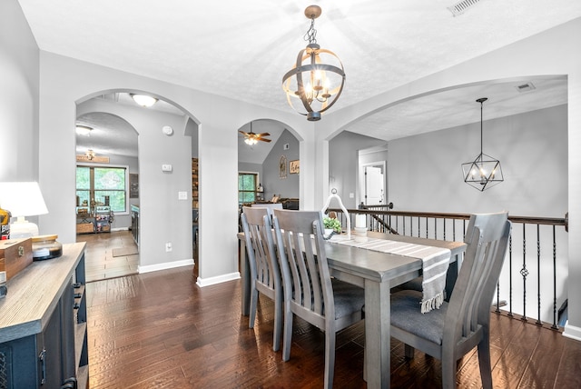 dining space with a textured ceiling, ceiling fan with notable chandelier, lofted ceiling, and dark hardwood / wood-style flooring