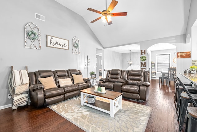 living room with ceiling fan with notable chandelier, high vaulted ceiling, and hardwood / wood-style flooring