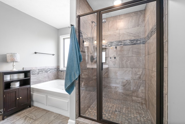 bathroom with shower with separate bathtub and a textured ceiling