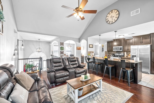 living room featuring high vaulted ceiling, ceiling fan, and dark hardwood / wood-style flooring