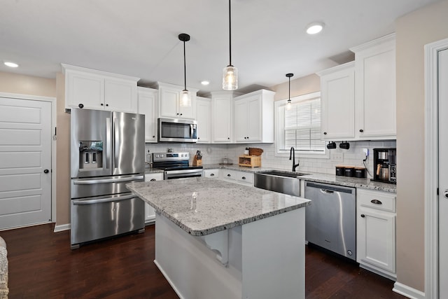 kitchen with stainless steel appliances, dark hardwood / wood-style flooring, white cabinetry, and a kitchen island