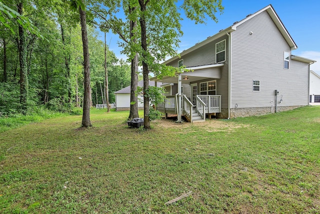 back of house featuring a lawn and a wooden deck