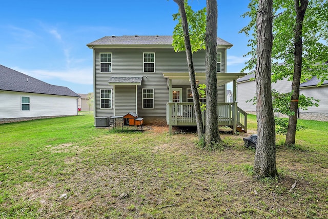 rear view of property featuring a wooden deck, central air condition unit, and a yard