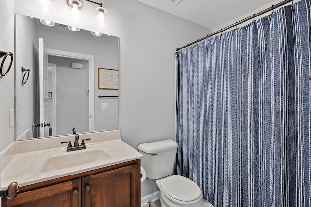 bathroom featuring curtained shower, vanity, and toilet