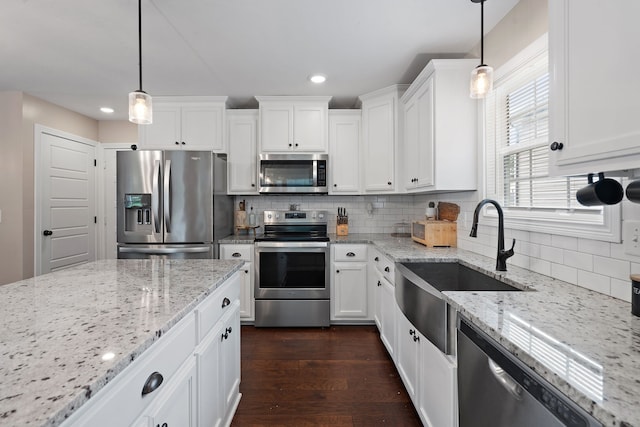 kitchen with appliances with stainless steel finishes, dark hardwood / wood-style flooring, pendant lighting, and white cabinets