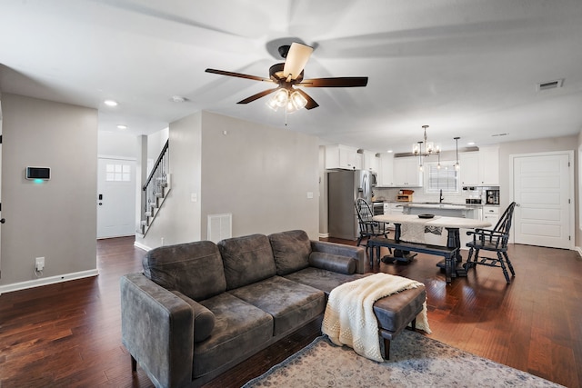 living room featuring ceiling fan with notable chandelier, hardwood / wood-style flooring, and sink