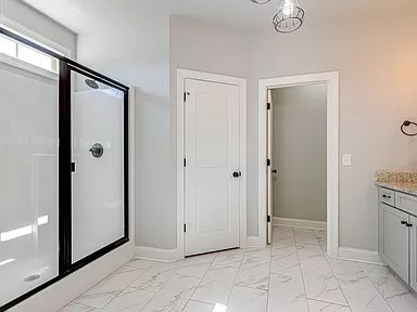 bathroom featuring vanity and a shower with shower door