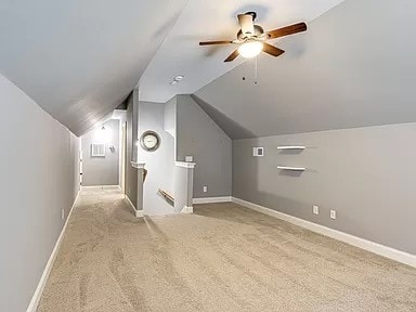 additional living space featuring vaulted ceiling, ceiling fan, and light colored carpet