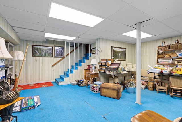 basement with a drop ceiling and carpet flooring