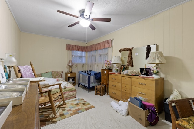 interior space with ceiling fan, wood walls, ornamental molding, a textured ceiling, and light colored carpet