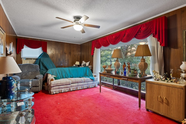 interior space with wooden walls, carpet, a textured ceiling, and ceiling fan