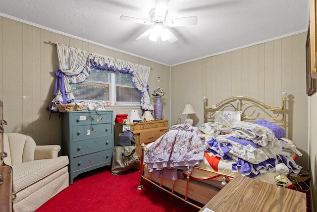 carpeted bedroom featuring wooden walls, ornamental molding, and ceiling fan