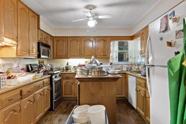 kitchen featuring ceiling fan, a kitchen island, appliances with stainless steel finishes, dark hardwood / wood-style floors, and crown molding