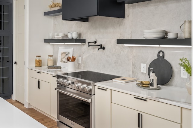 kitchen with stainless steel range and light hardwood / wood-style floors