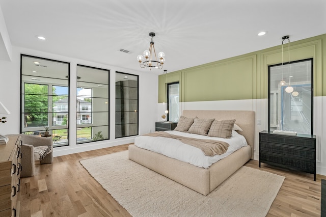 bedroom with an inviting chandelier and light hardwood / wood-style floors