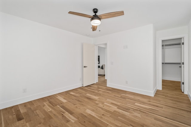 unfurnished bedroom featuring ceiling fan, light wood-type flooring, and a closet