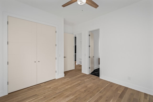 unfurnished bedroom with ceiling fan, light hardwood / wood-style flooring, and a closet